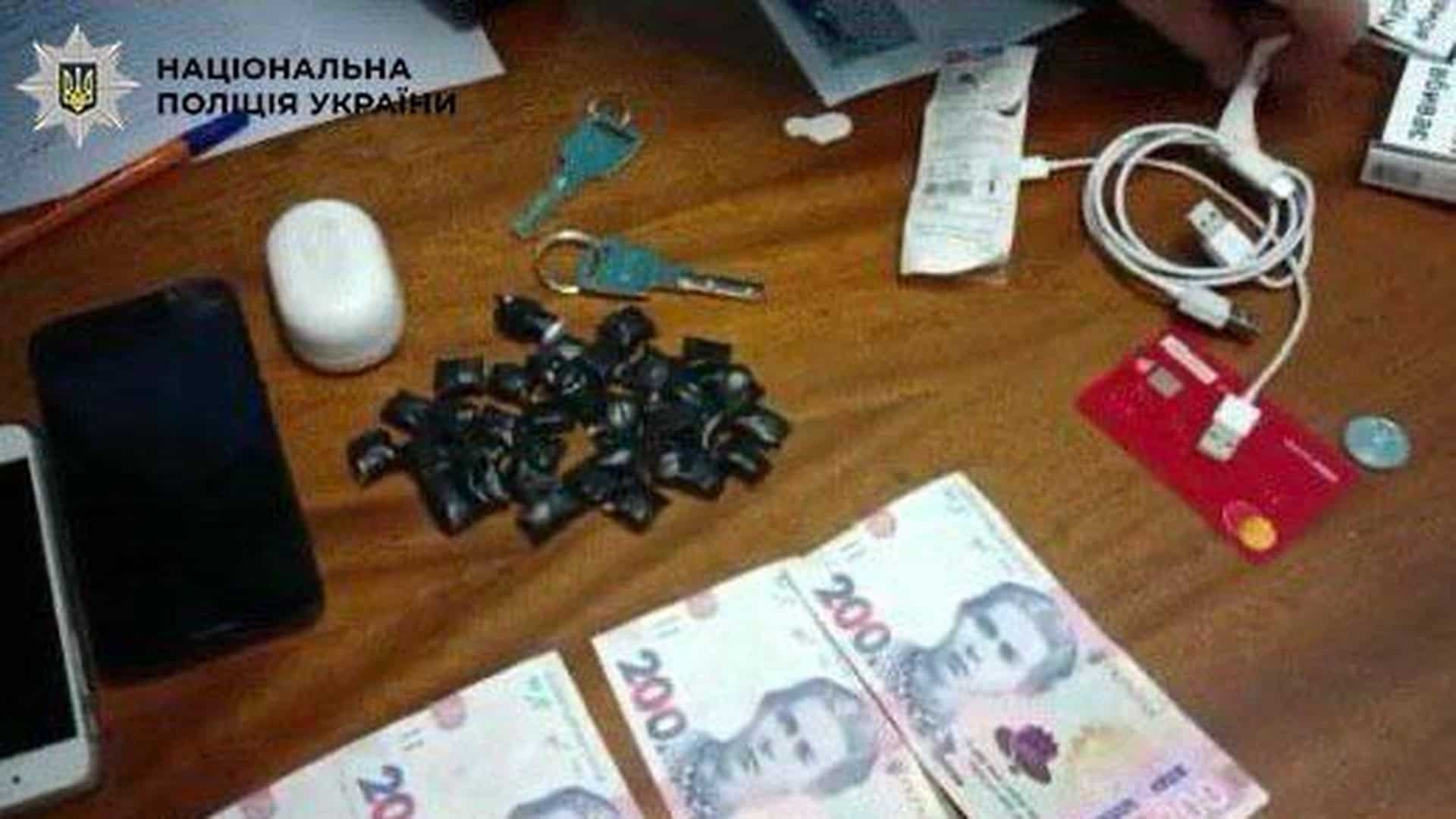 Вилучені речові докази у справі наркозбувача у метро «Житомирська» — згортки метадону, гроші, телефон, ключі на столі