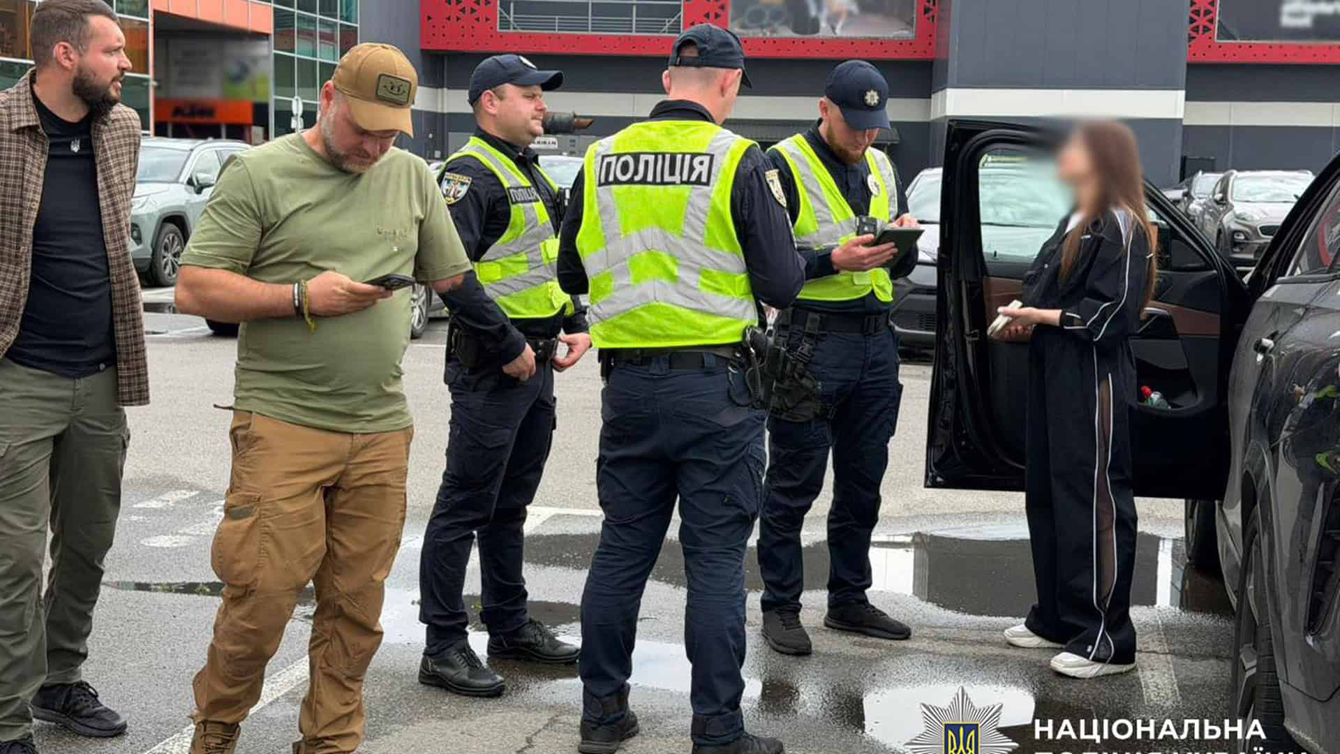 Патрульні поліцейські разом із ветеранами перевіряють паркування на спеціальних місцях для осіб з інвалідністю на парковці торгового центру в Києві