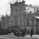 Архівне чорно-біле фото: кінна карета швидкої допомоги, городові та натовп киян біля рятувальної станції на Володимирській, 33