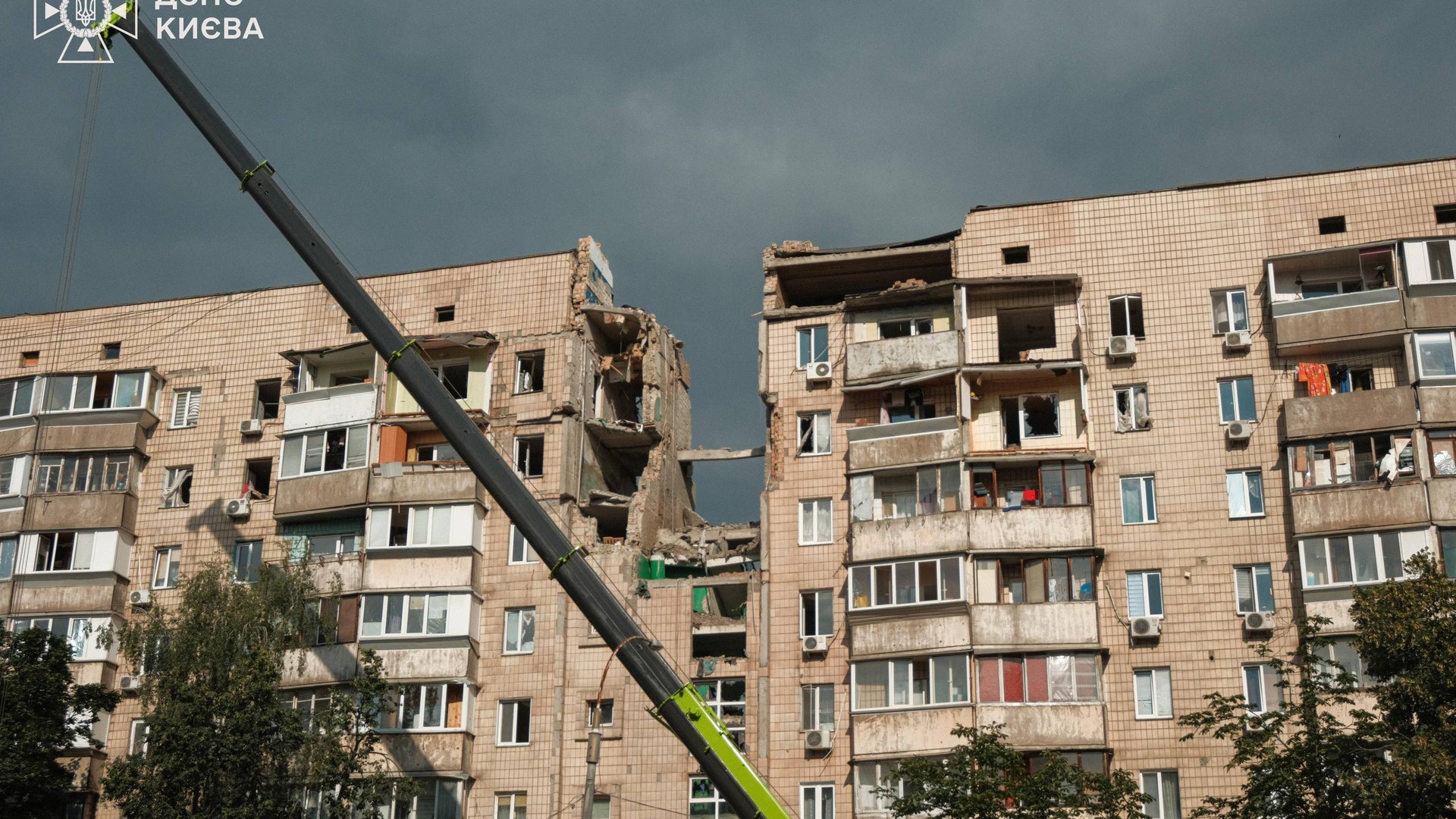 Атака на Київ: 19 загиблих, 58 поранених у двох районах (оновлено) Автокран біля пошкодженої багатоповерхівки в Дарницькому районі Києва після російської атаки, зруйновані верхні поверхи будинку
