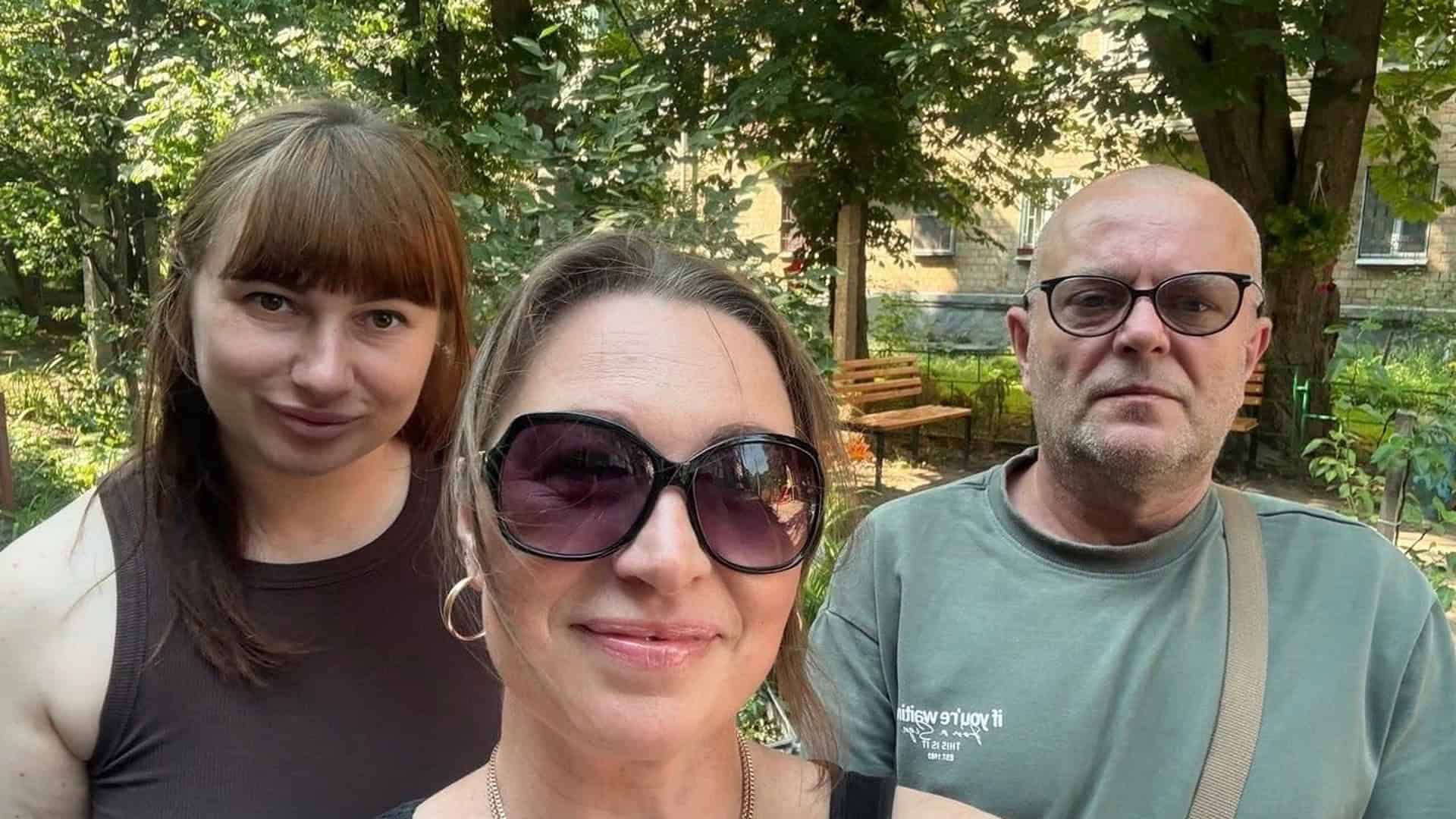 Троє активістів вулиці Сокальської на Оболоні позують для селфі у дворі серед зелені під час зустрічі з представниками РМБО