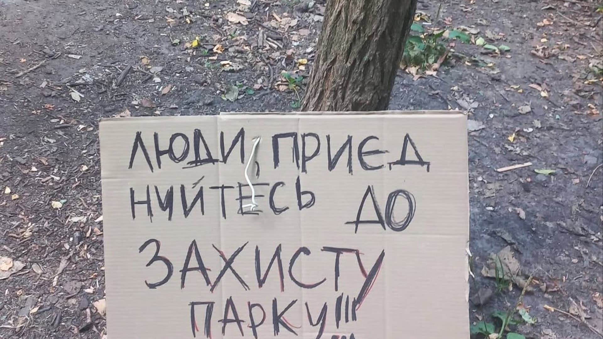 Саморобна табличка «Люди, приєднуйтесь до захисту парку!!!» на дереві в лісосмузі на Теремках
