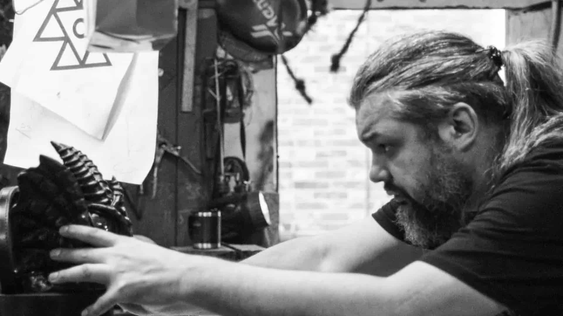 Засновник артстудії Bob Basset працює над шкіряною маскою у своїй харківській майстерні, оточений ескізами та інструментами
