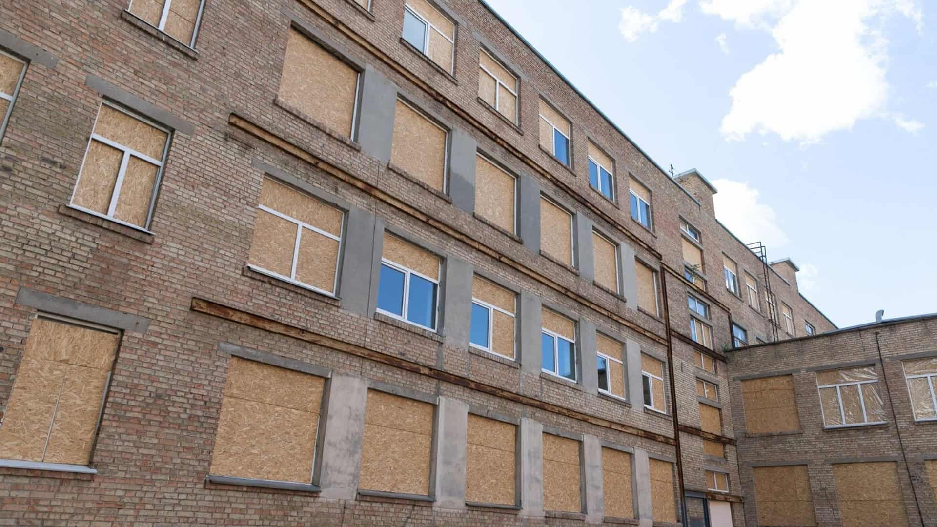 Навчальний рік у Києві завершується 29 травня Фасад київської школи, пошкодженої російським обстрілом: більшість вікон забиті ОСБ-плитами, частина вже засклена