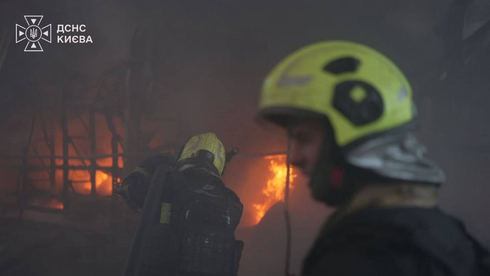 Пожежники ДСНС гасять полум’я в задимленому приміщенні на місці обстрілу в Києві вночі