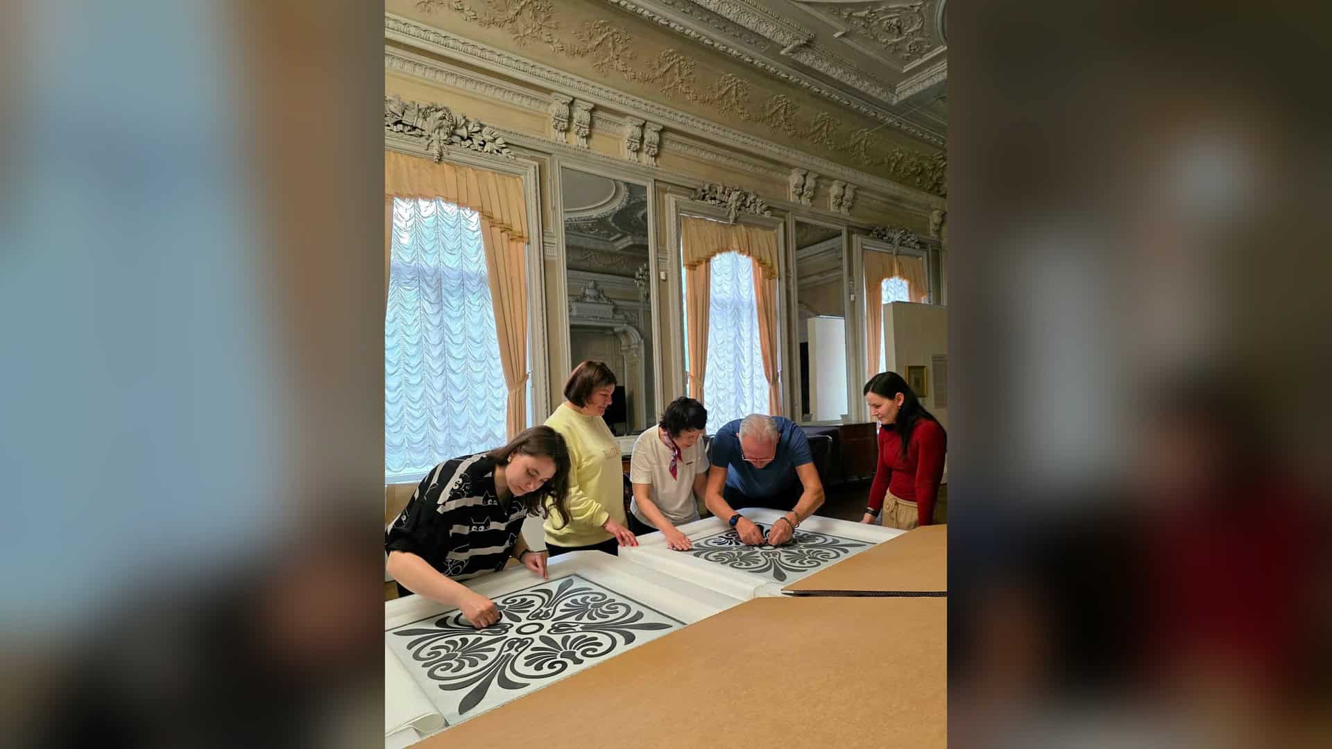 «Хлібні» Софії Київської відкрили виставку до 95-річчя Дубовика Реставратори оглядають відтворені елементи вітража Київської картинної галереї на столі