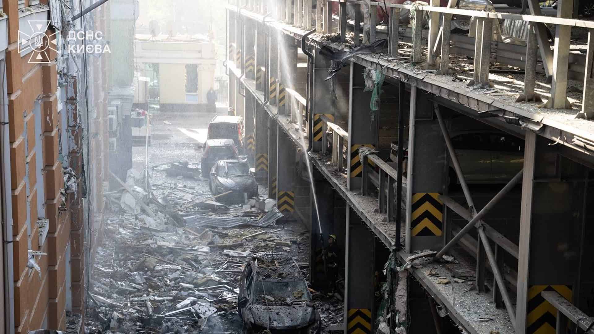 Двоє загиблих і 36 постраждалих: Київ атакували БпЛА у чотирьох районах Завали уламків і знищені автомобілі біля багаторівневого паркінгу в Києві, рятувальник ДСНС гасить осередки пожежі