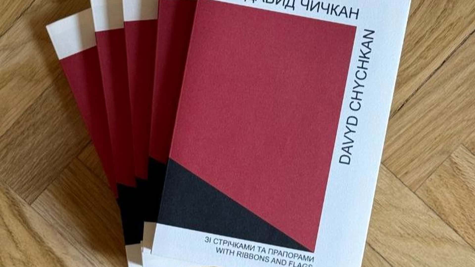 Андріївська церква провела інклюзивний майстер-клас для учнів спецшколи Кілька примірників книги Давида Чичкана «Зі стрічками та прапорами» з червоно-чорною обкладинкою на паркеті