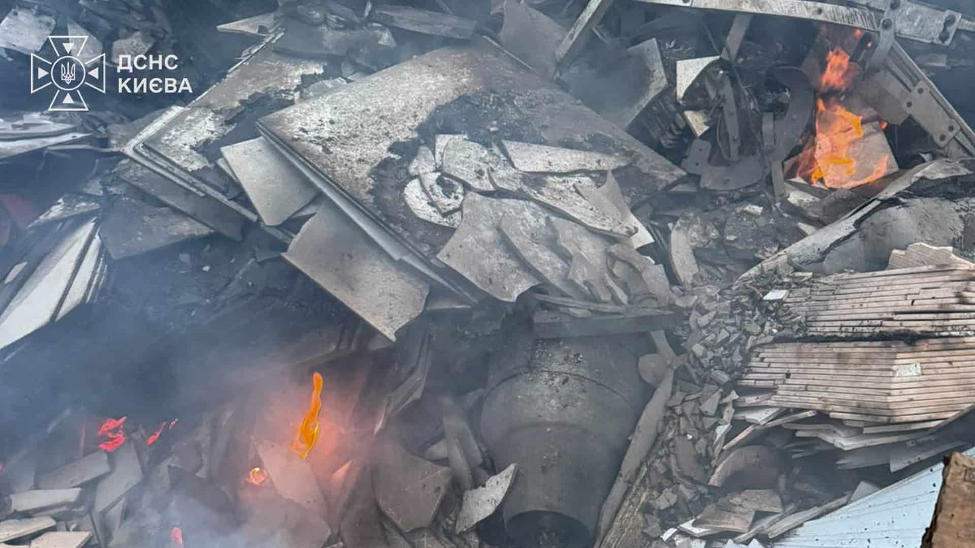 Ракета у Дарницькому р-ні: вибухотехніки розміновують снаряд серед будинків Осередок вогню серед металевих уламків та завалів на місці пожежі в Києві після нічної атаки, кадр ДСНС.