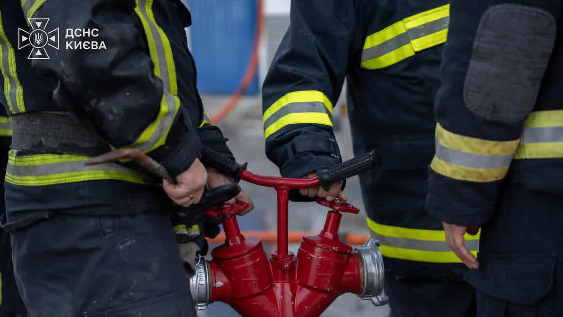 БпЛА впав на бізнес-центр у Голосіївському р-ні — екстрені служби на місці Рятувальники ДСНС у захисному спорядженні відкривають червоний пожежний гідрант на місці ліквідації наслідків атаки