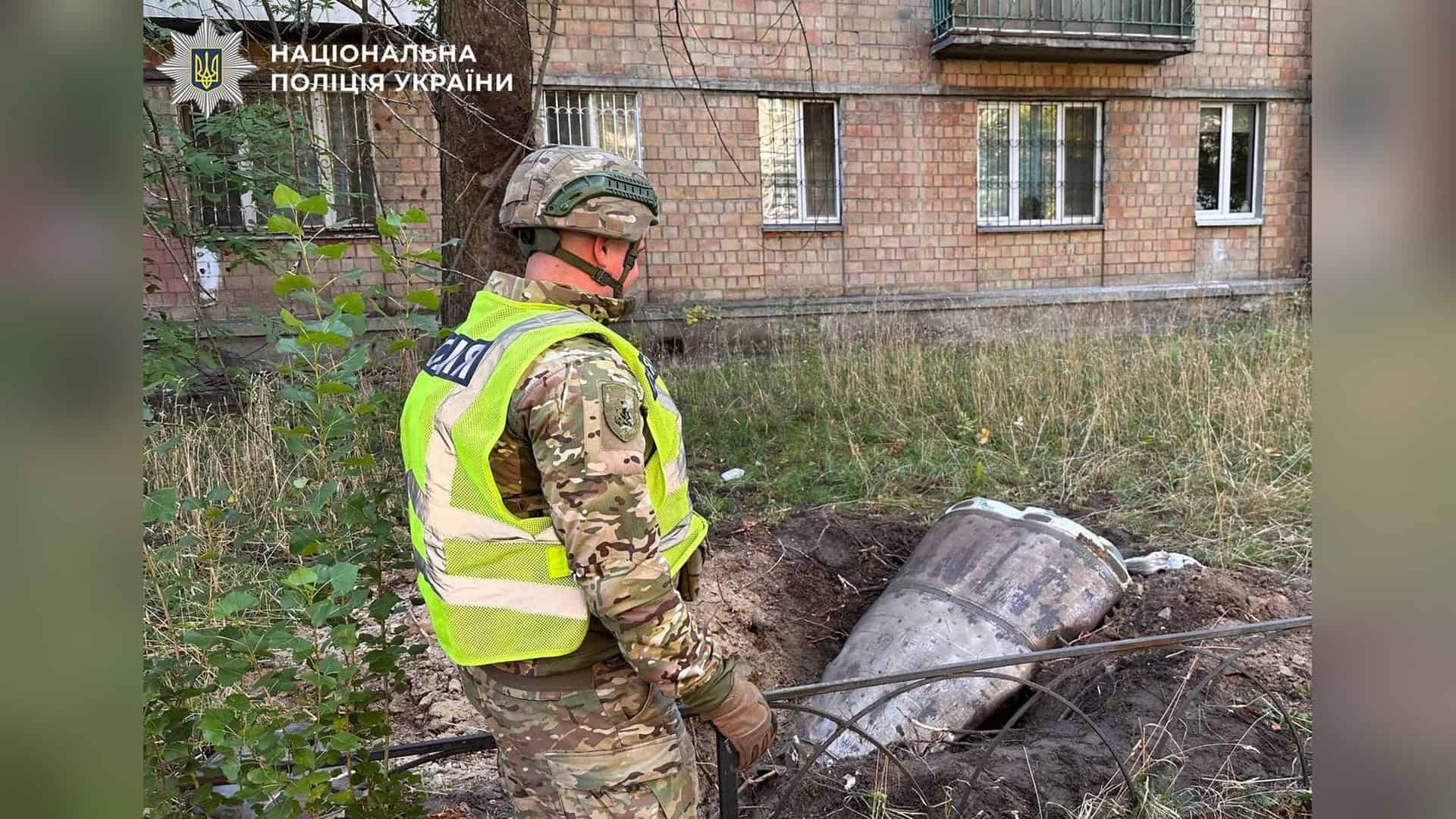 Пожежа у Подільському р-ні після влучання — екстрені служби на місці Поліцейський вибухотехнік у шоломі й жилеті стоїть біля бойової частини ракети, що лежить у ямі перед житловим будинком у Солом’янському р-ні