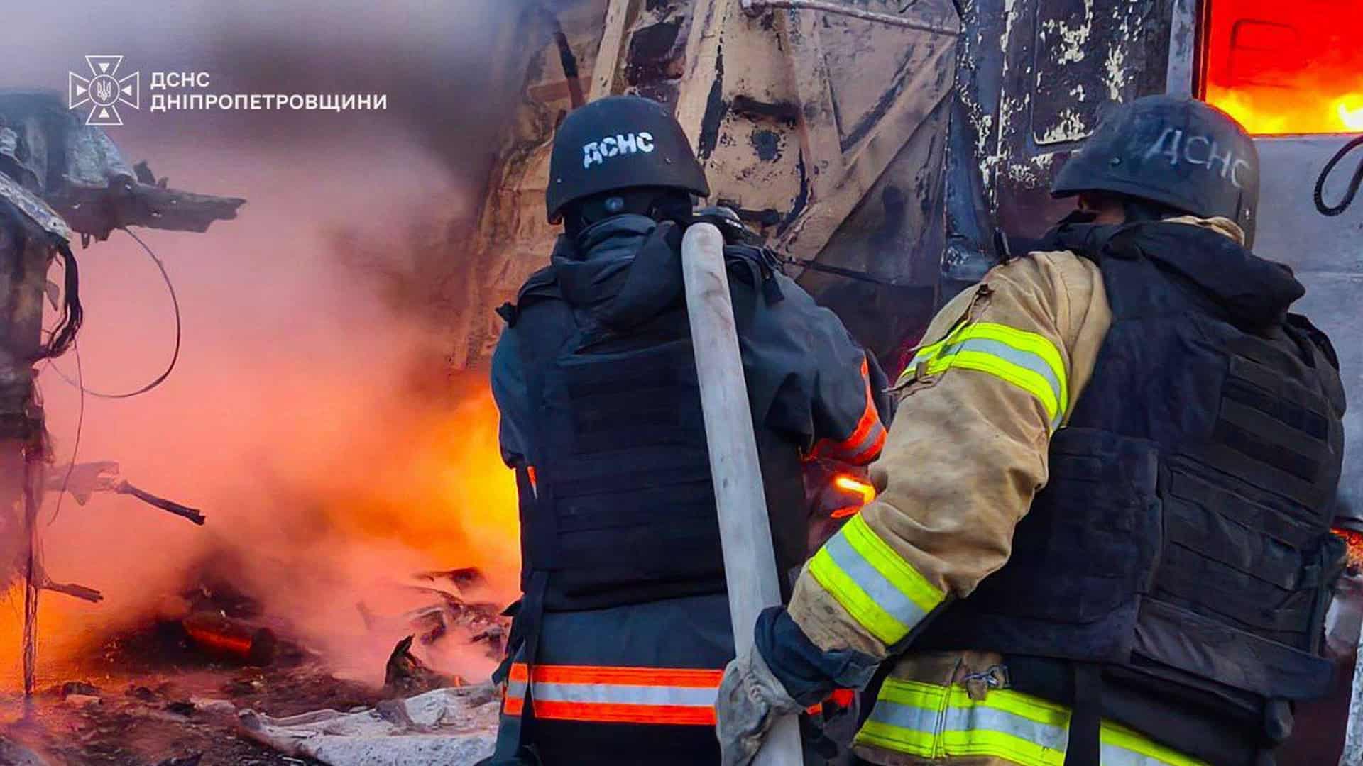 Вночі ворог атакував Київ: пожежі у Дарницькому та Голосіївському р-нах Двоє рятувальників ДСНС Дніпропетровщини в бронежилетах працюють з пожежним стволом на тлі сильного полум'я