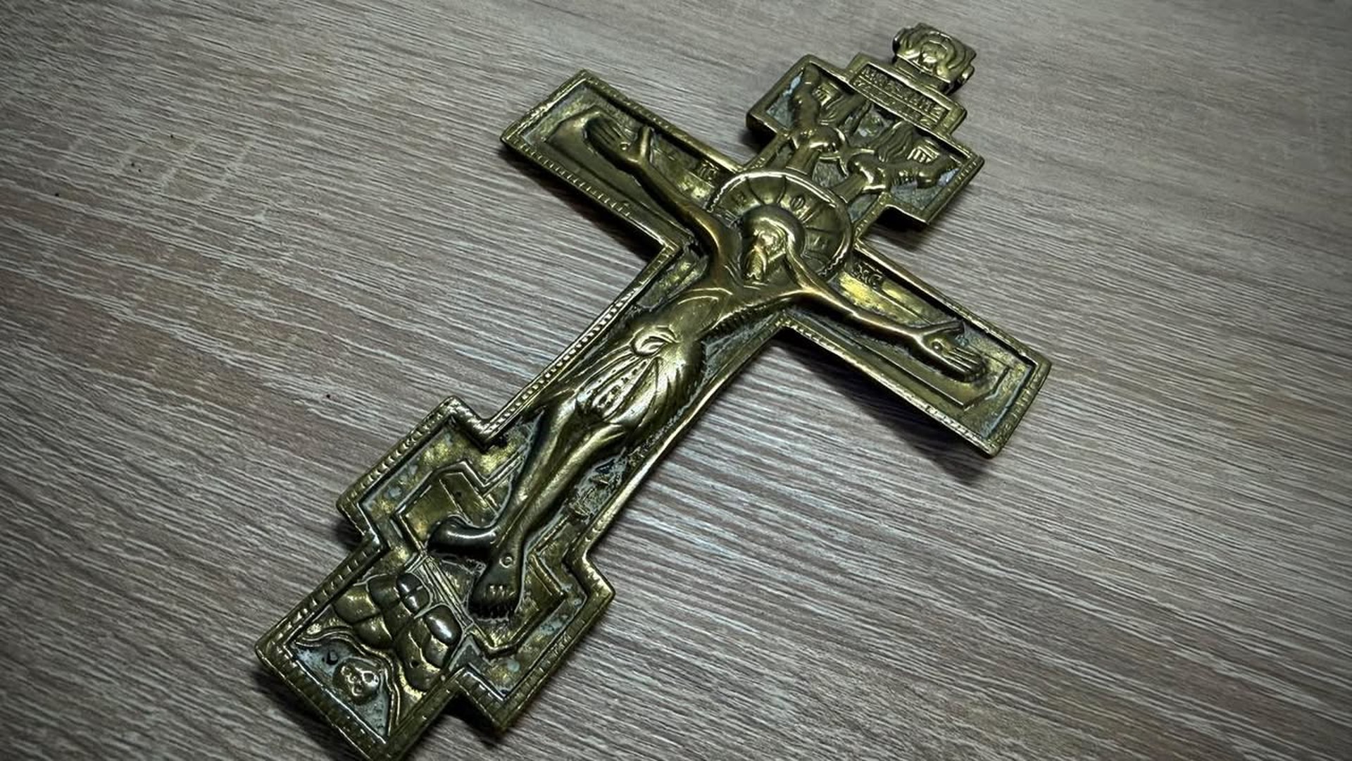 Киянина підозрюють у крадіжці телефона в переході під час ракетної атаки Мідний восьмикінцевий хрест-розп’яття зі старовинним рельєфом на сірій дерев’яній поверхні — один із предметів, вилучених Київською митницею