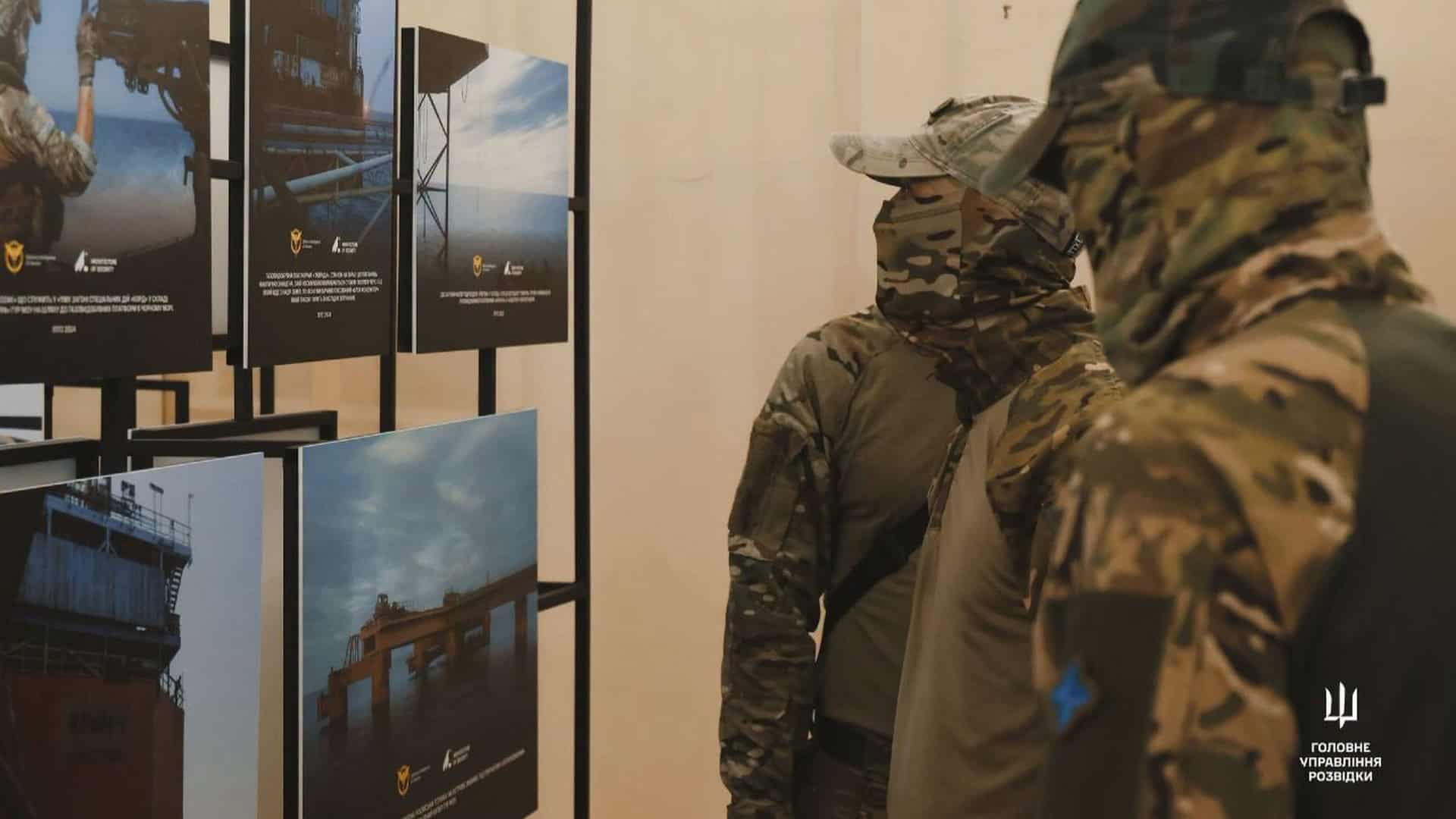 Українські військовослужбовці розглядають світлини на фотовиставці ГУР у Центральному будинку офіцерів ЗСУ в Києві