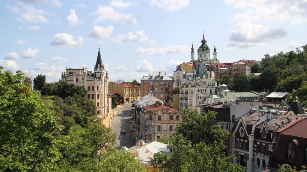 Андріївський узвіз з Андріївською церквою і «Замком Ричарда» серед зелені — вид згори в заповіднику «Стародавній Київ»
