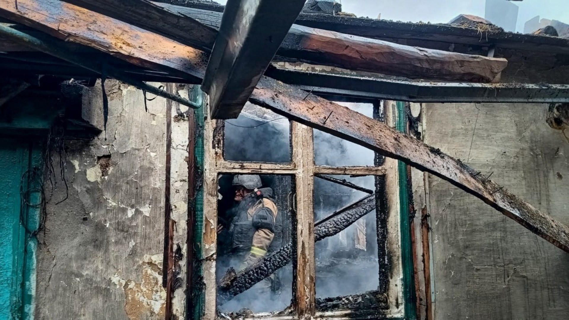 Рятувальник у задимленому згорілому приватному будинку з обвугленими балками даху після нічної атаки 19 жовтня