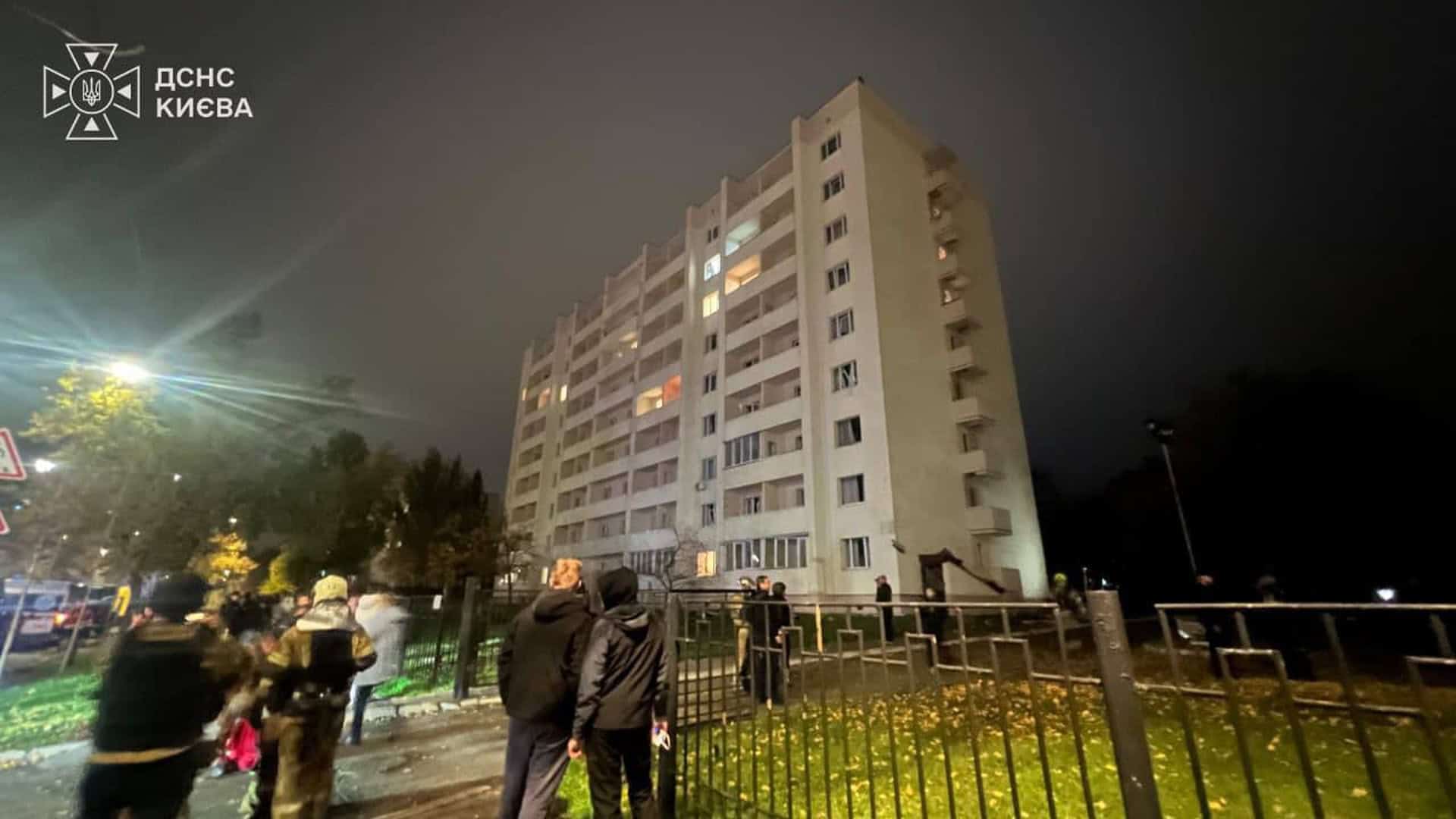 Рятувальники ДСНС і люди біля багатоповерхового гуртожитку в Деснянському р-ні Києва після атаки ввечері 26 жовтня