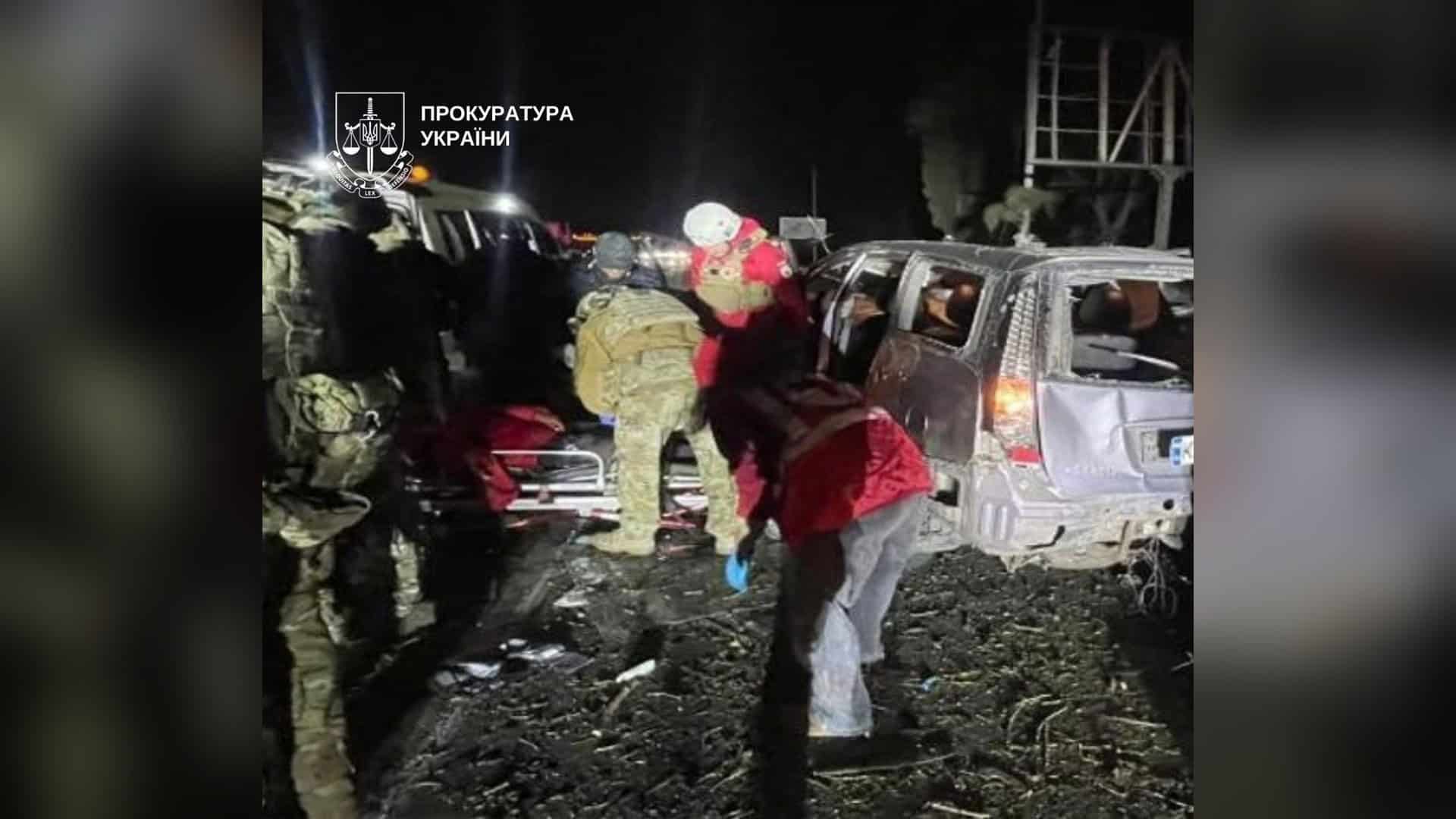 Медики й військові біля пошкодженого автомобіля з вибитими вікнами вночі після російської атаки на Київ 26 жовтня