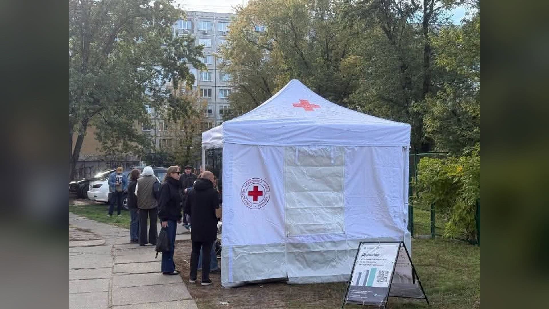 Мешканці біля намету Червоного Хреста з гарячим харчуванням поруч із багатоповерхівкою у Деснянському р-ні Києва