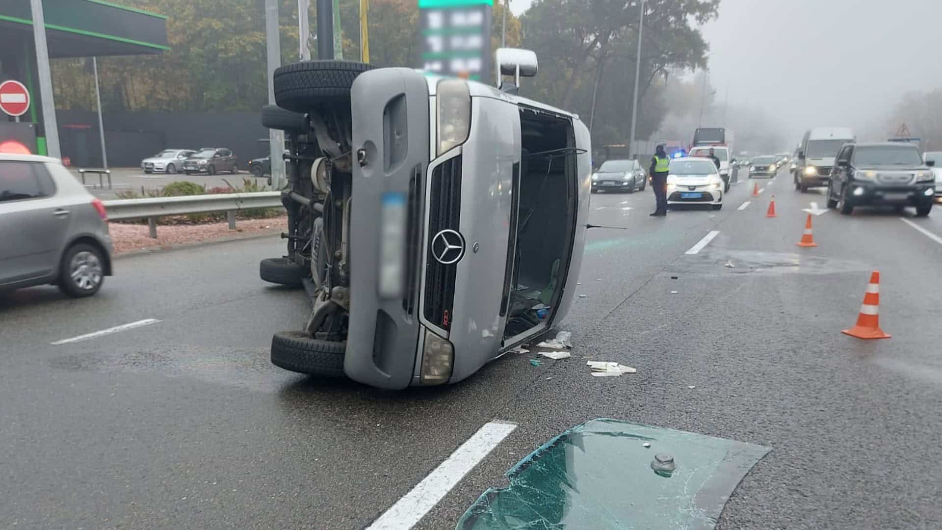 Маршрутний автобус лежить на боці на Берестейському шосе в Києві, поруч уламки скла, конуси й патрульне авто