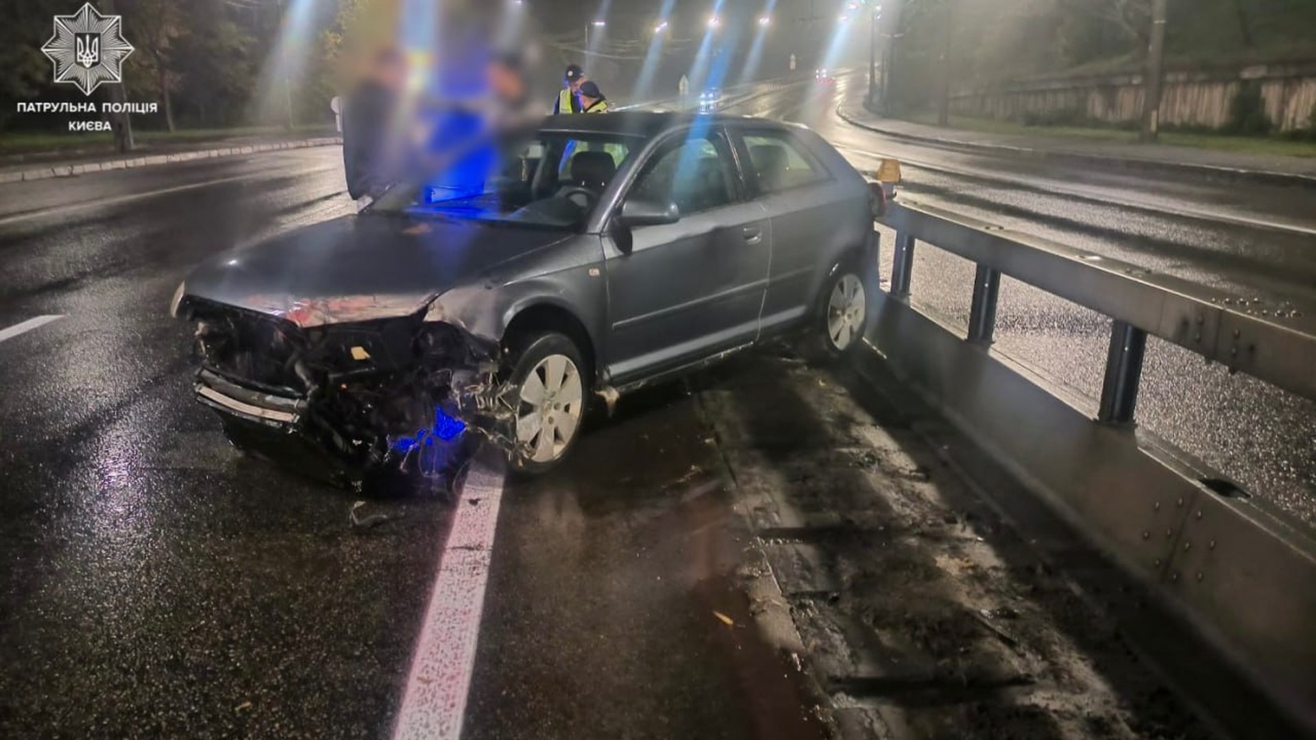 За два дні у Києві «замінували» понад тисячу об’єктів: усі повідомлення виявилися хибними Сірий хетчбек із розбитою передньою частиною біля металевого відбійника на мокрій вул. Олени Теліги вночі, поруч патрульні