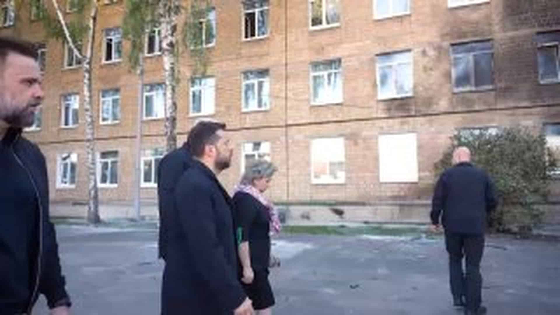 Посадовці оглядають пошкоджену чотириповерхову цегляну школу в Солом’янському р-ні Києва після удару «шахеда», вікна вибиті, фасад у кіптяві