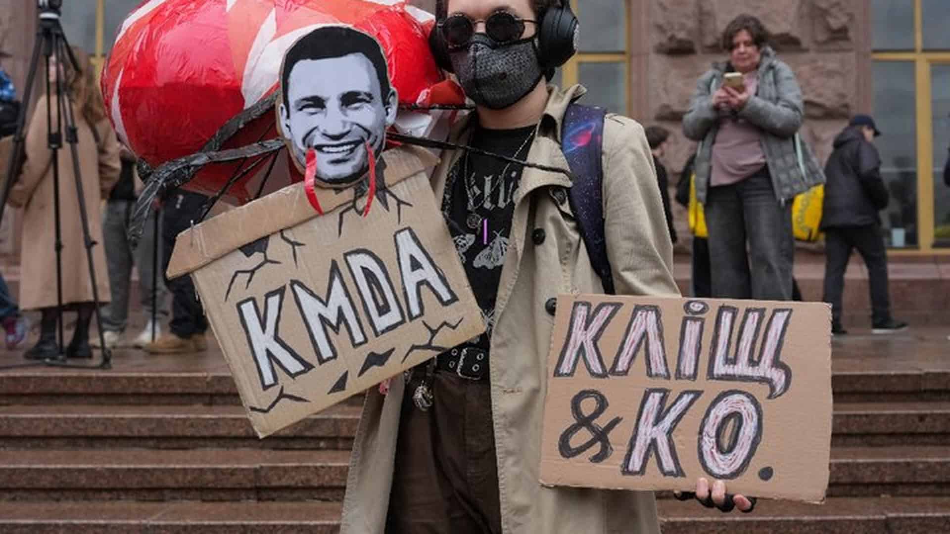 Учасник мітингу під будівлею КМДА тримає саморобні плакати з вимогою відставки міського голови Віталія Кличка