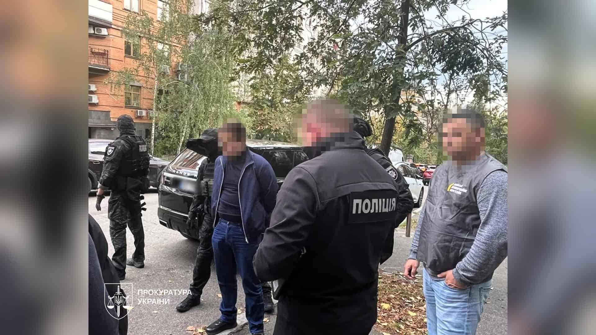 Поліцейські та прокурор на вулиці в Києві під час затримання чоловіка, якого підозрюють у виманюванні грошей від імені НАБУ