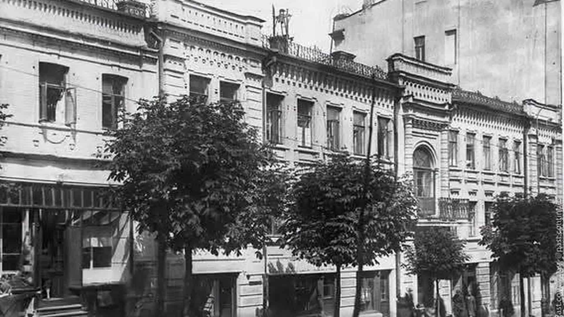 Будинок на Прорізній, 22А: фасад із фігурної цегли й двоколонним портиком Чорно-біле історичне фото триповерхового будинку на Прорізній, 22А у Києві з цегляним декором фасаду та деревами перед ним