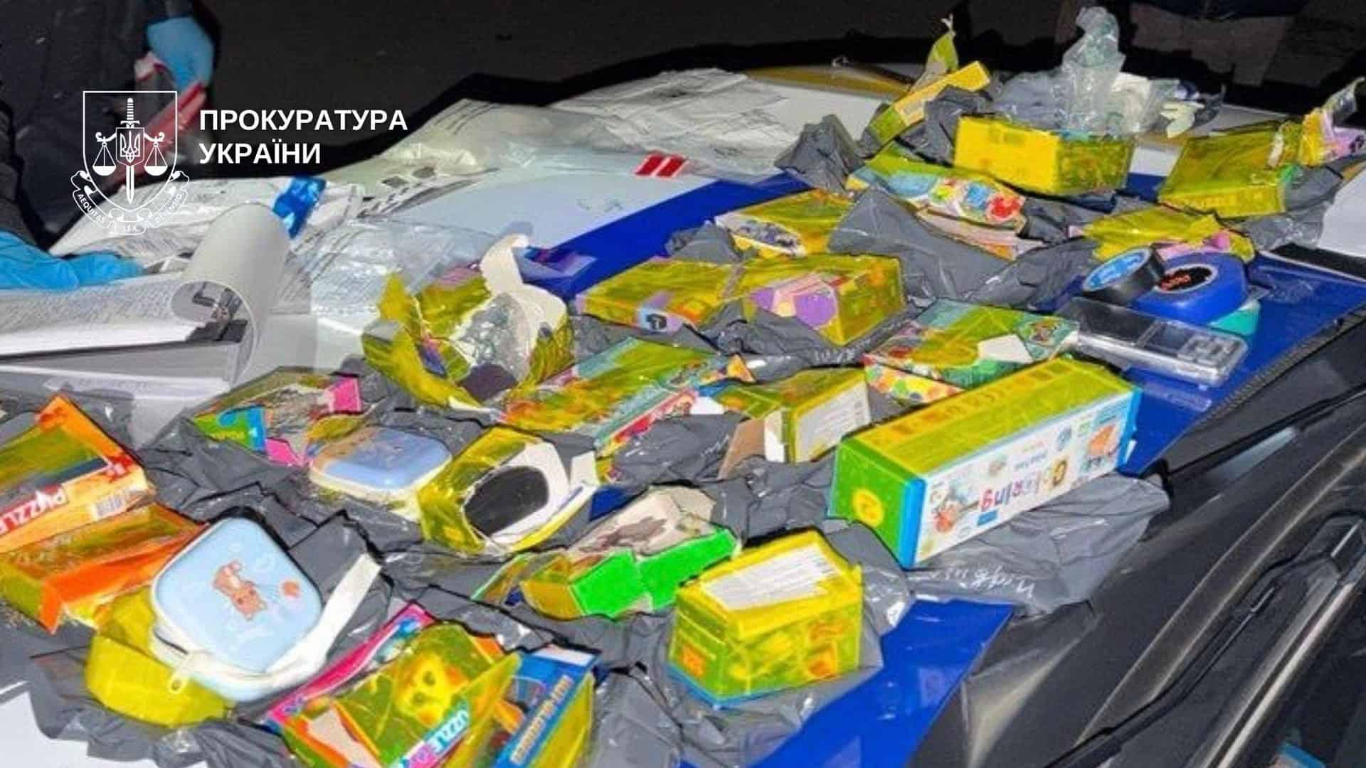 Киянка передала 2 тис. доларів після дзвінка «з СБУ»: підозра 18-річному Розпаковані коробки з дитячими пазлами й канцелярією, у яких, за версією слідства, ховали психотропи, на капоті поліцейського авто
