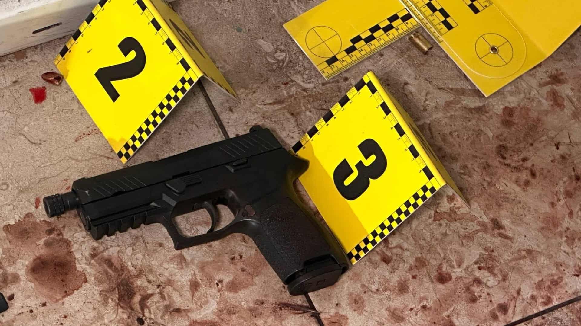 Пістолет і слідчі маркери на підлозі в приміщенні ТЦК у Печерському р-ні Києва після стрілянини 19 жовтня