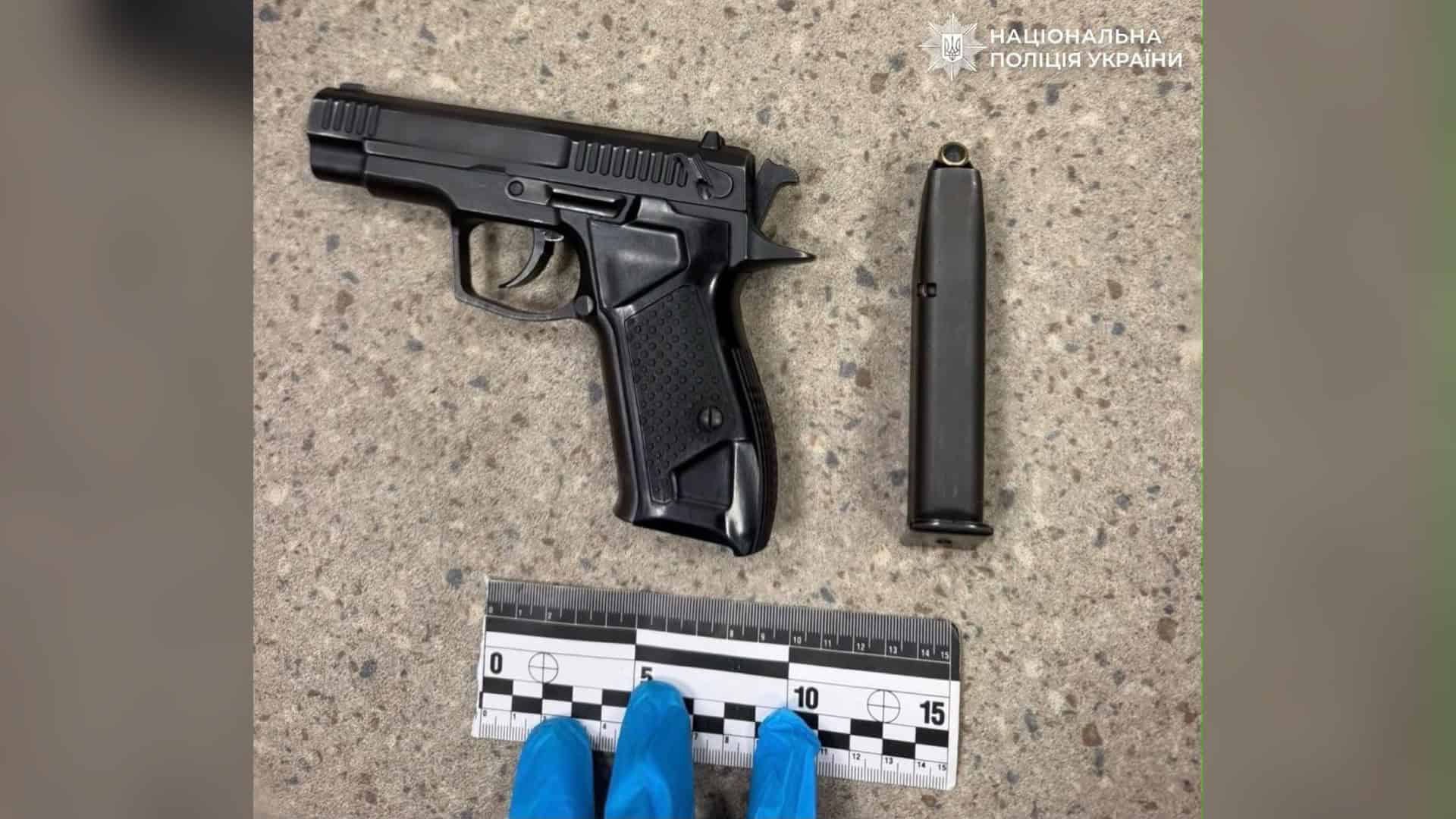 Травматичний пістолет «Форт-12РМ» і магазин поруч з криміналістичною лінійкою, вилучені поліцією Києва після пострілів у дворі