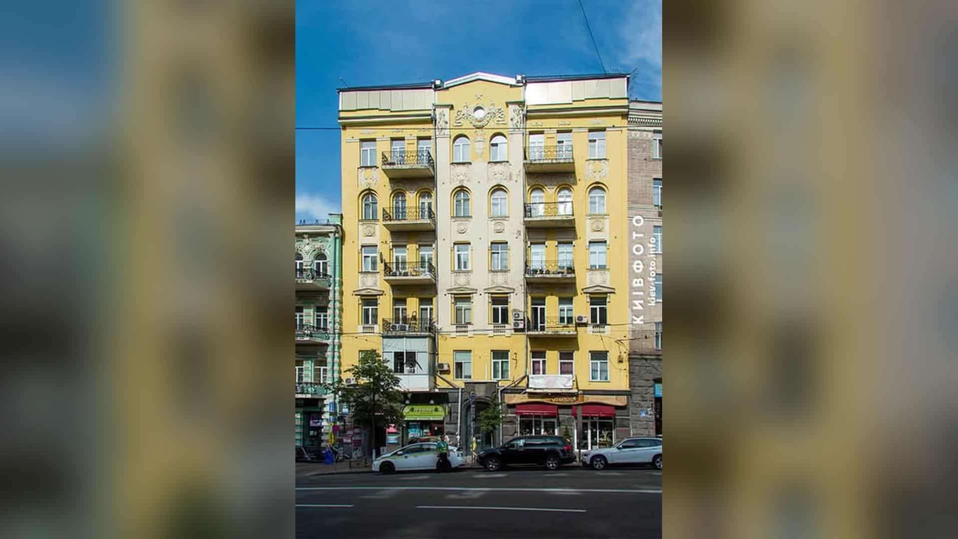 Жовтий шестиповерховий будинок на вулиці Великій Васильківській, 26 у Києві з ліпним декором і балконами на фасаді