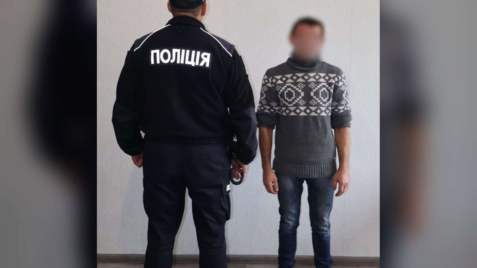 Поліцейський у формі поруч із 37-річним чоловіком, якому на Бориспільщині повідомили про підозру в катуванні пасинка