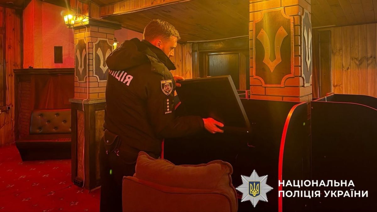 Поліцейський оглядає гральний автомат під час обшуку в незаконному гральному закладі у Вишгороді на Київщині