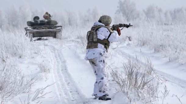 Солдат закамуфльований в білий на фоні снігу та танку