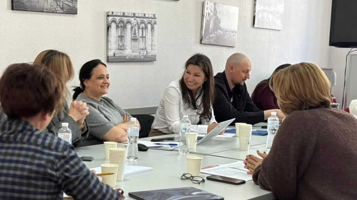 Учасники робочої зустрічі НСЗУ з директорами київських центрів первинної медико-санітарної допомоги сидять за столом переговорів у Департаменті охорони здоров'я КМДА