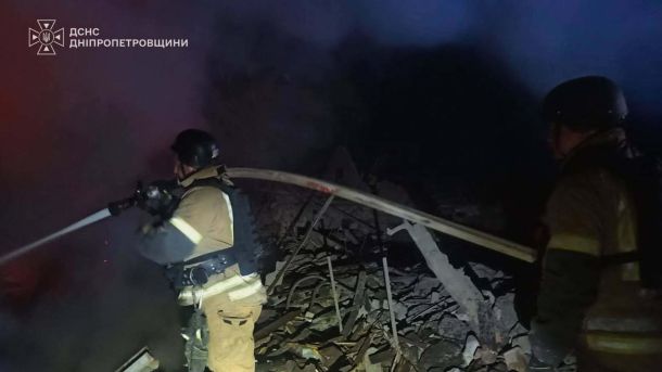 Рятувальники ДСНС гасять пожежу на завалах зруйнованої будівлі після нічної атаки, працюють зі стволом у диму