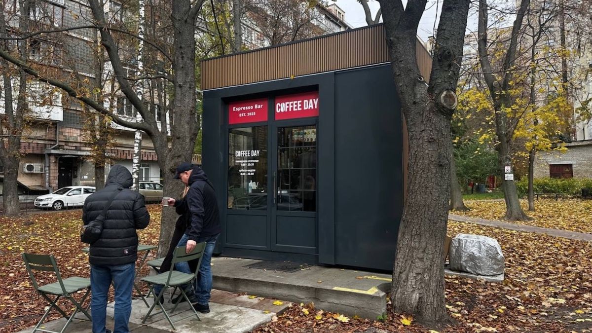 Новий кіоск Coffee Day встановлений за єдиним архетипом реформи МАФів у Києві серед осіннього листя на тлі житлових будинків
