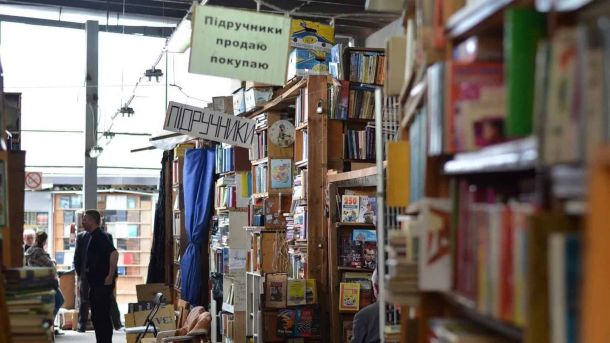 У Хлібні зіграли на 15 домрах одразу — Bouquet Kyiv Stage Книжкові ряди ринку біля метро Почайна: стелажі з книгами та вивіски про купівлю і продаж підручників