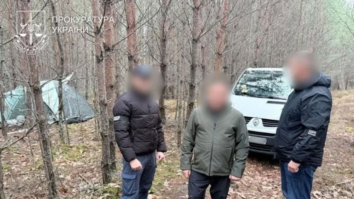 чоловіків із розмитими обличчями стоять у лісі поруч із білим мікроавтобусом і наметом