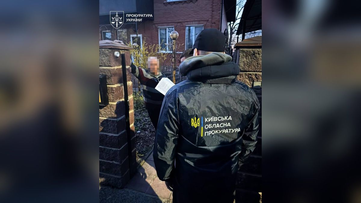 Співробітник Київської обласної прокуратури вручає підозру фігуранту справи про розтрату бюджетних коштів на будівництві меморіалу в Ірпені