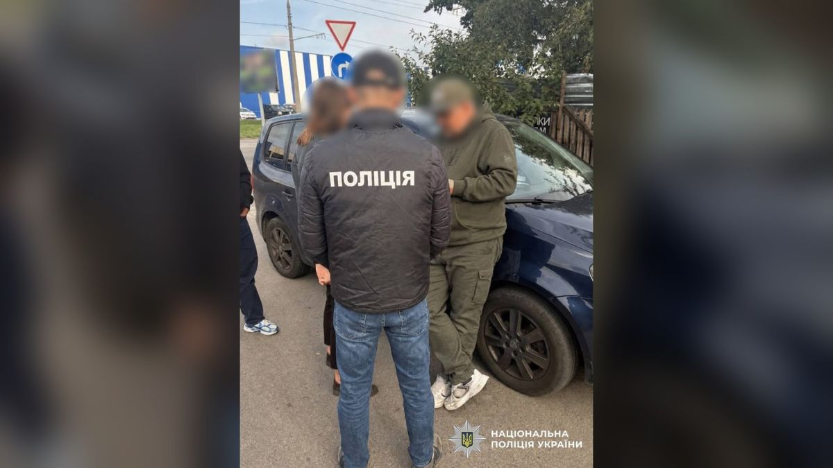 Хабарі за газ і вирубку дерев: на Київщині підозра трьом посадовцям Поліцейський і чоловік в оливковому одязі біля синього автомобіля під час затримання посадовців на Київщині
