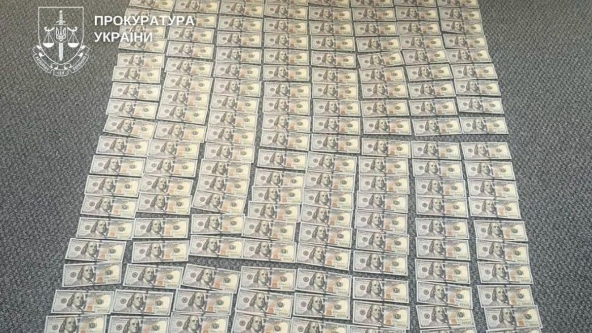 Розкладені банкноти номіналом по 100 доларів у справі про ухилення від сплати податків на Київщині