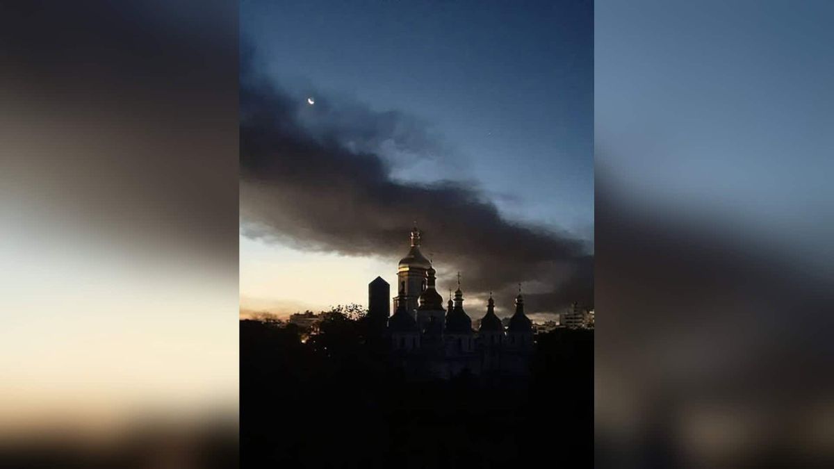 Силует Софійського собору в Києві на тлі темного диму в небі після російської атаки, сутінки, видно місяць