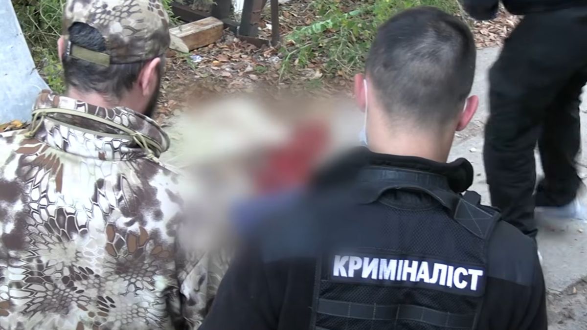 Криміналіст поліції та слідчі працюють на місці вбивства охоронця спортивної бази на Трухановому острові в Києві