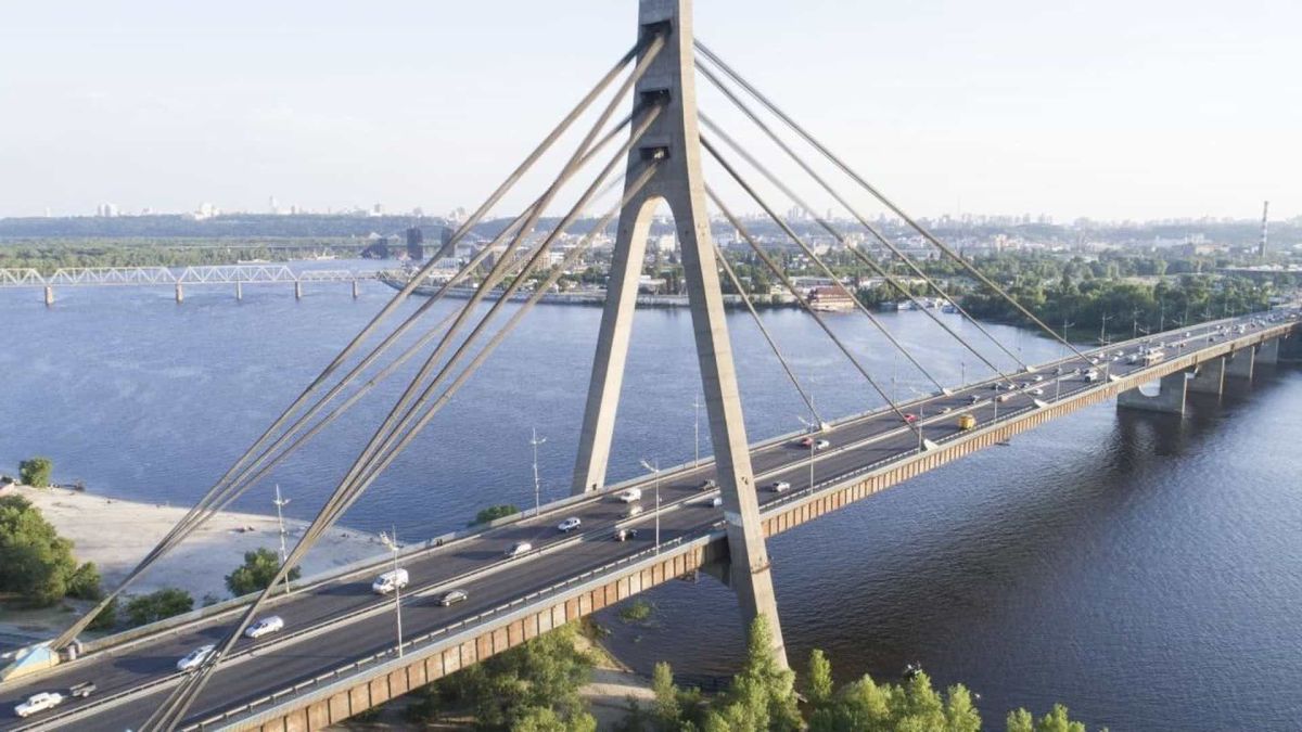 Вантовий Північний міст через Дніпро в Києві з висоти: автомобілі на мосту, позаду лівий берег і залізничний міст