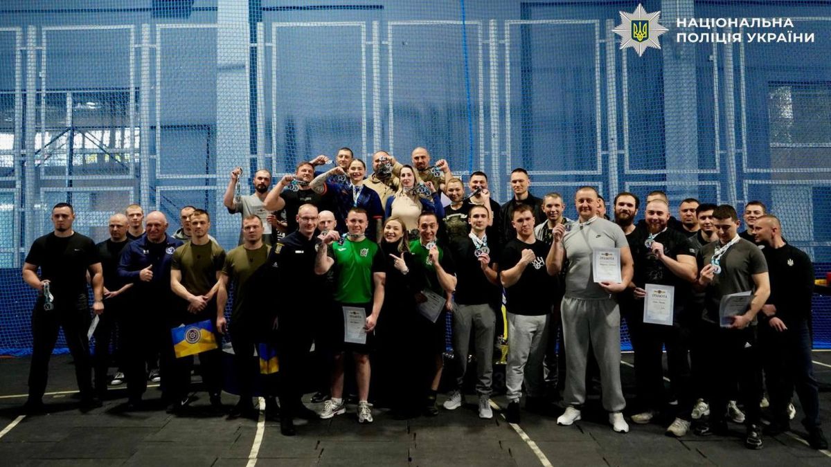 Поліцейські київського гарнізону після турніру з армрестлінгу — учасники з медалями та грамотами на тлі спортивного залу