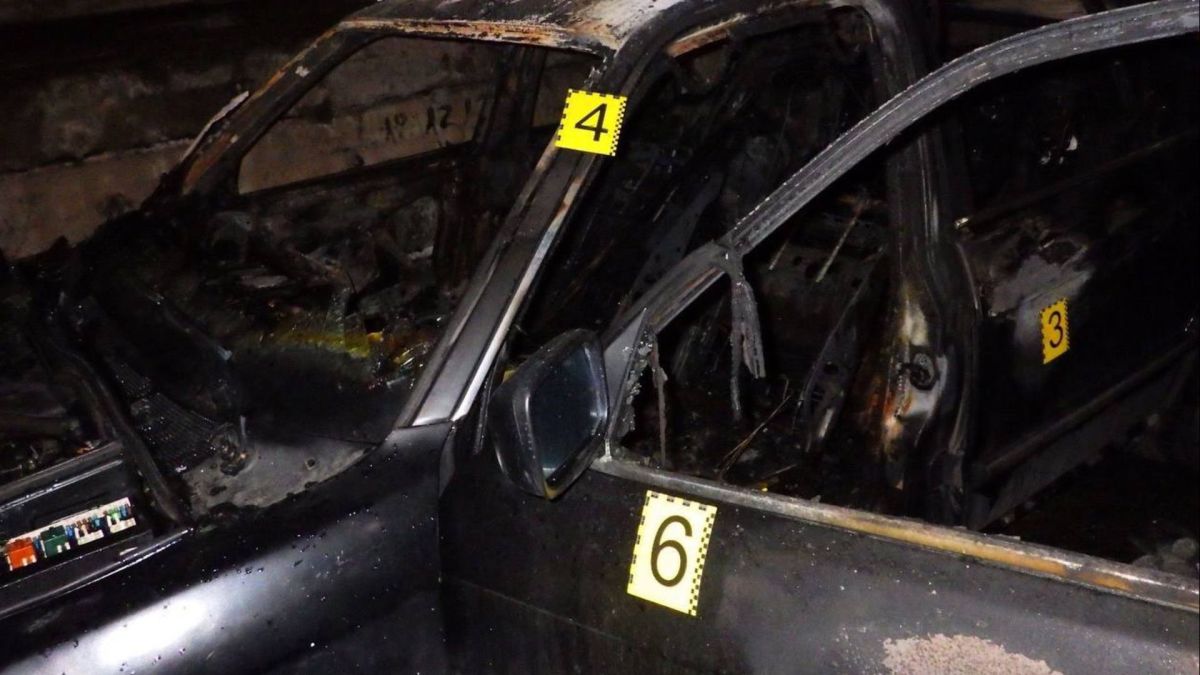 Обгорілий автомобіль BMW з криміналістичними маркерами після підпалу зловмисниками у Дніпровському районі Києва