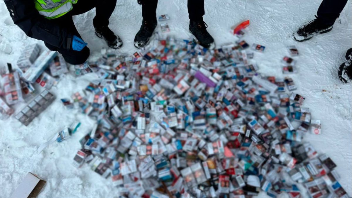 Вилучена тютюнова продукція, розсипана на снігу під час огляду поліцейськими місця злочину у Дніпровському районі Києва